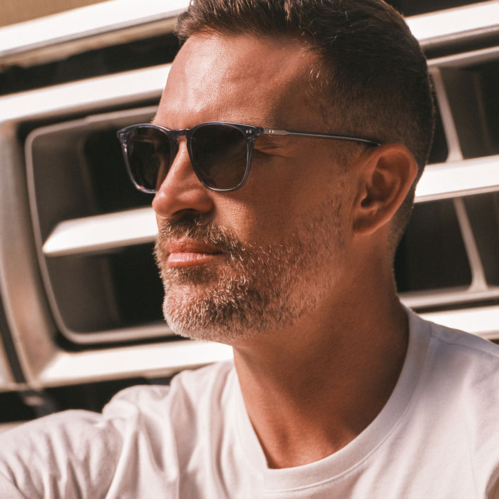 lifestyle - male wearing diff eyewear maxwell square sunglasses with a blue night sky frame and grey gradient polarized lens side view