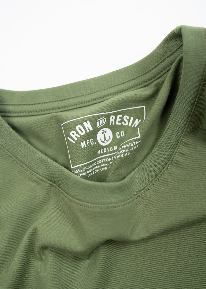 Green t-shirt with "Iron and Resin" label, made from 100% organic cotton, manufactured in Pakistan, size medium.