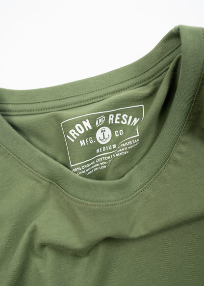 Green t-shirt with "Iron and Resin" label, made from 100% organic cotton, manufactured in Pakistan, size medium.