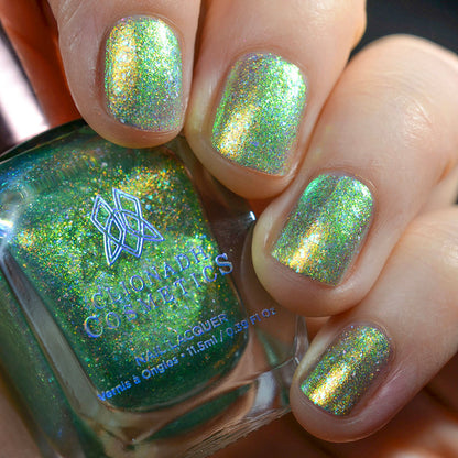 Close-up of nails painted with Ophelia Nail Lacquer on fair skin tone. Hand is holing polish bottle.