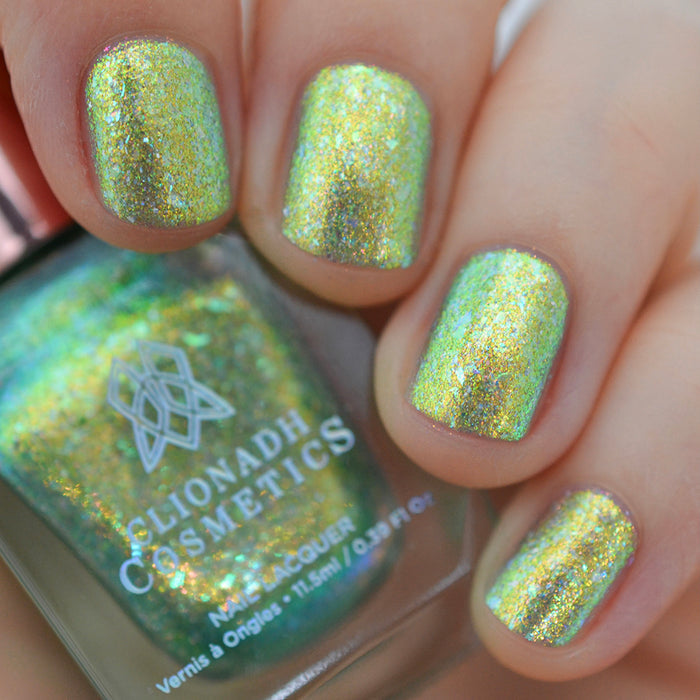 Close-up of nails painted with Ophelia Nail Lacquer on fair skin tone. Hand is holding polish bottle.