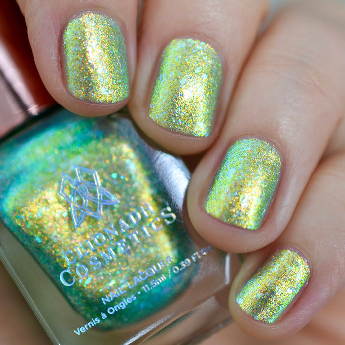 Close-up of nails painted with Ophelia Nail Lacquer on fair skin tone. Hand is holding polish bottle.