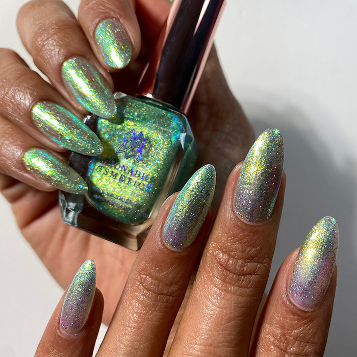 Nails painted with Ophelia Nail Lacquer on medium skin tone. hand is holding polish bottle.