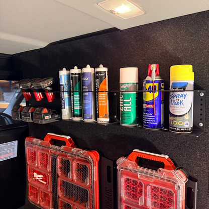 Collection of spray cans and toolboxes on a black shelf