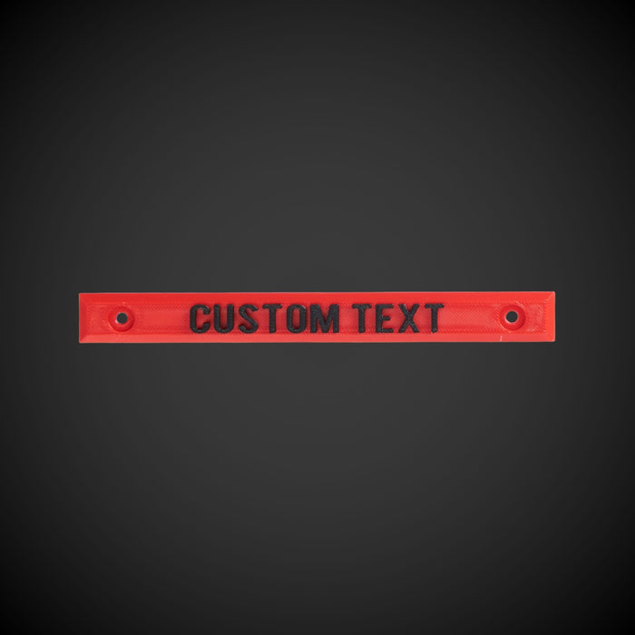 A red custom text screw on label that is designed to be screw on, with text space provided for personalization.