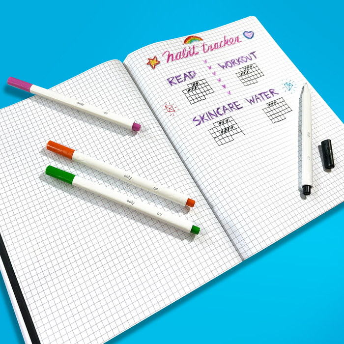 Habit tracker made with OOLY Seriously Fine Tip Markers in a graph paper notebook with a blue background