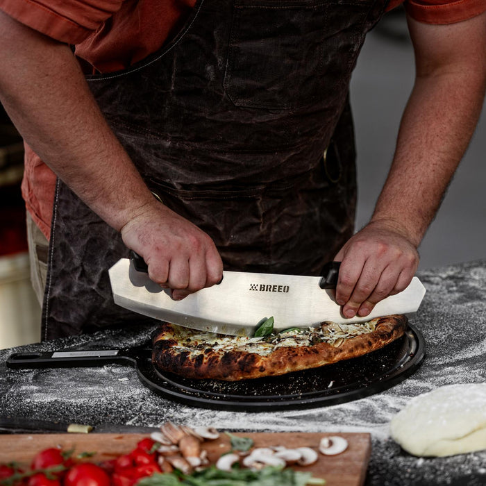 This is an image of someone using the Rocker to slice a pizza on the Serving Board.