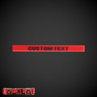 A custom text label in red on a black background, designed to clip onto a Milwaukee packout handle.