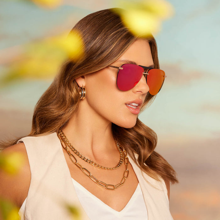 on female model wearing diff eyewear tahoe aviator sunglasses with a matte gold metal frame and sunset mirror lenses