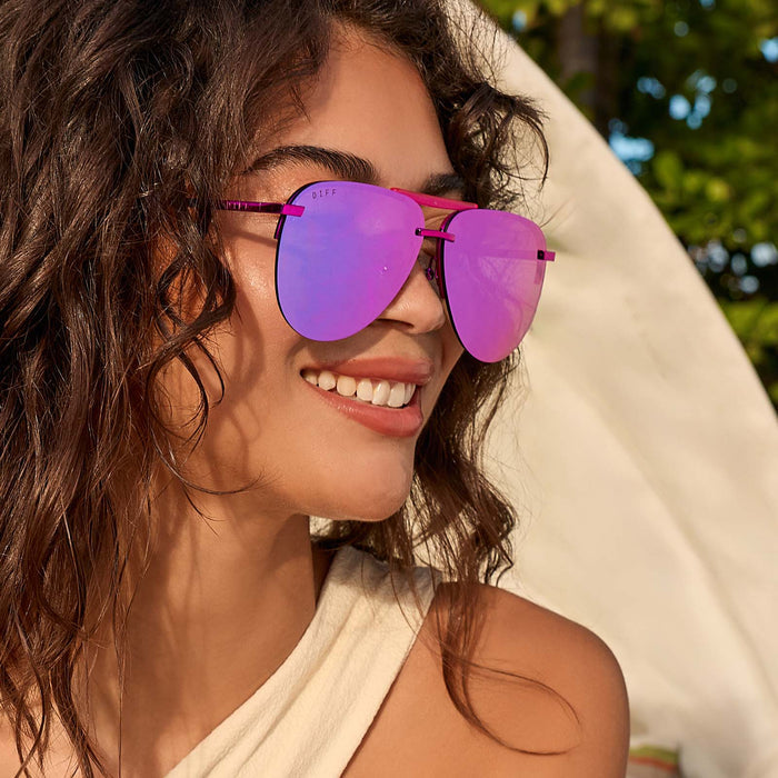 lifestyle - female smiling wearing diff eyewear tahoe aviator sunglasses with a pink rush metallic frame and pink rush mirror lenses angled view