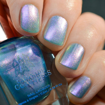 Close-up of nails painted with Tessera Nail Lacquer on fair skin tone. Hand is holding polish bottle.