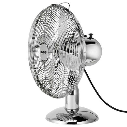 Der Unold TISCHVENTILATOR CHROME ist ein metallisch glänzender Tischventilator mit rundem Standfuß, Schutzgitter, sichtbaren Flügeln und einem schwarzen Netzkabel, das auf der Rückseite herausragt.