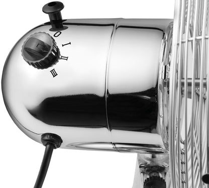 Nahaufnahme des Unold TISCHVENTILATOR CHROME. Hervorzuheben sind die metallische Oberfläche, der Leistungs- und Geschwindigkeitsregler (Einstellungen 0, I, II, III), das schwarze Netzkabel und ein Abschnitt des Drahtgitters über den Ventilatorflügeln.