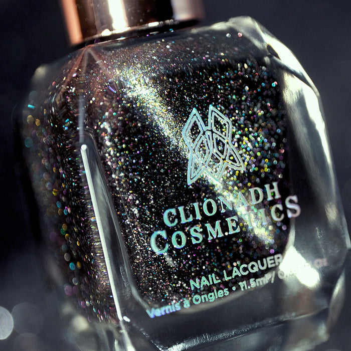 Angled, close-up of Tombstone Nail Lacquer bottle on a black background.