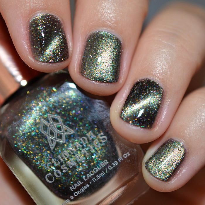 Close-up of nails painted with Tombstone Nail Lacquer on fair skin tone. Hand is holding polish bottle.