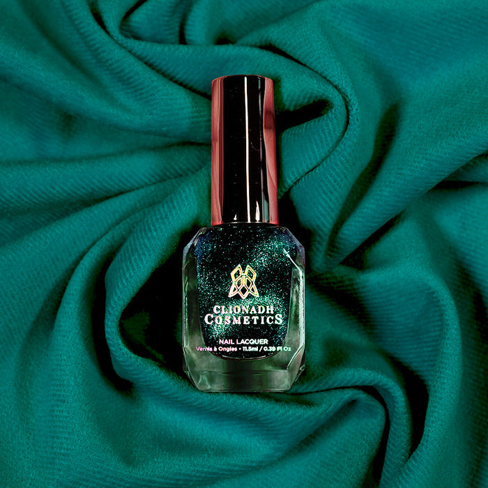 Bottle of nail polish containing Turquoise Silk on a teal fabric background.