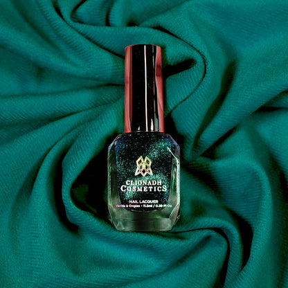 Bottle of nail polish containing Turquoise Silk on a teal fabric background.