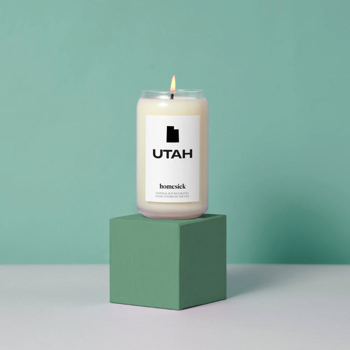 The Utah candle on top of green cube displayed on a light gray surface with a mint green background.