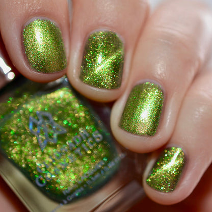 Close-up of nails painted with Velvet Verdigris Nail Lacquer on fair skin tone. Hand is holding polish bottle.