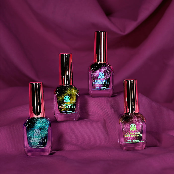 Four bottles of Clionadh Cosmetics nail polish standing on a purple fabric background.