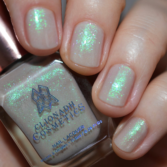 Close-up of nails painted with Venus Nail Lacquer on fair skin tone. Hand is holding polish bottle.