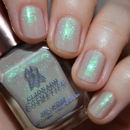 Close-up of nails painted with Venus Nail Lacquer on fair skin tone. Hand is holding polish bottle.