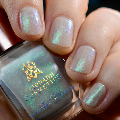 Close-up of nails painted with Venus Nail Lacquer on fair skin tone. Hand is holding polish bottle.