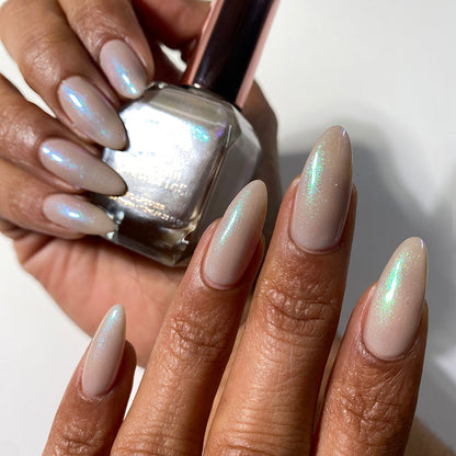 Nails painted with Venus Nail Lacquer on medium skin tone. Hand is holding polish bottle.