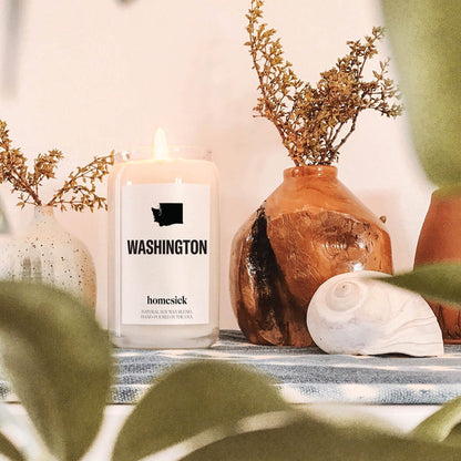 A close up of the Washington candle amongst various greenery home decor items.