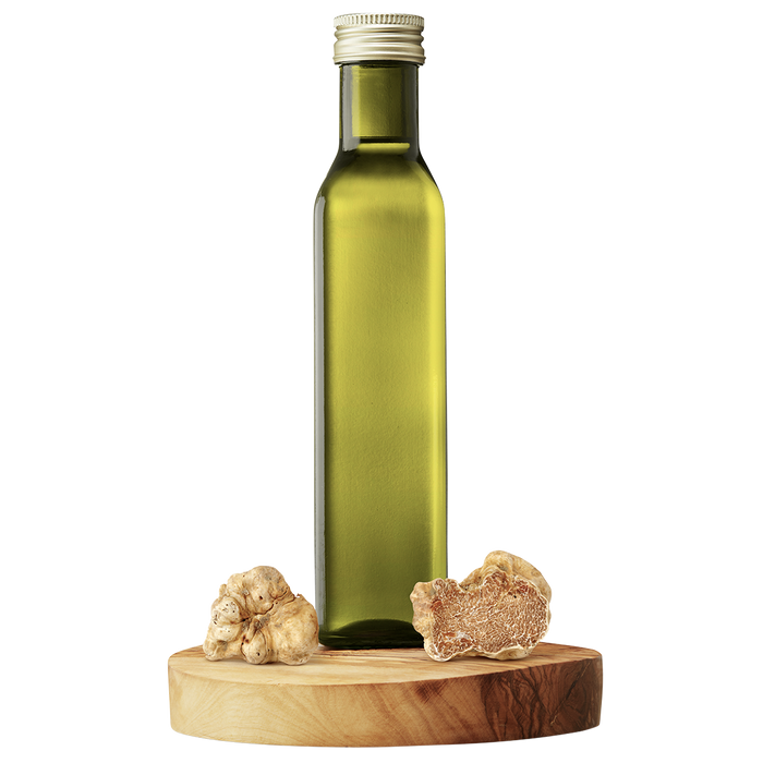 A bottle of extra virgin olive oil with a piece of white truffle next to it, all set on a wooden platform.