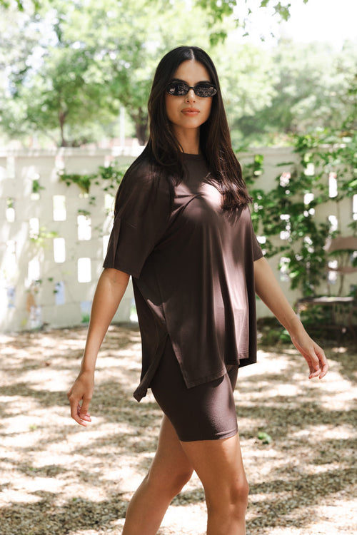 Close up of female walking wearing an oversized dark brown shirt with matching biker shorts