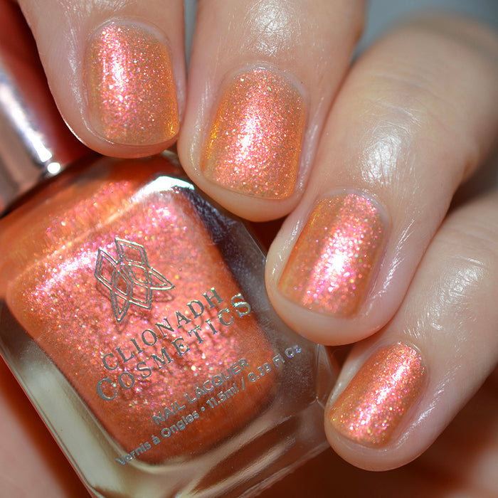 Close-up of nails painted with Yuzu Limonada Nail Lacquer on fair skin tone. Hand is holding polish bottle.