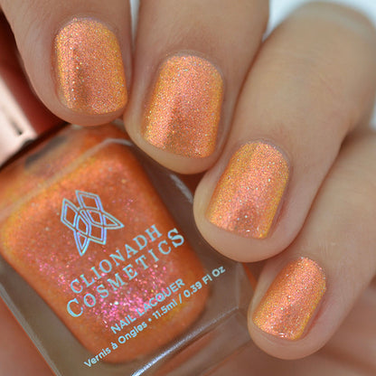 Close-up of nails painted with Yuzu Limonada Nail Lacquer on fair skin tone. Hand is holding polish bottle.