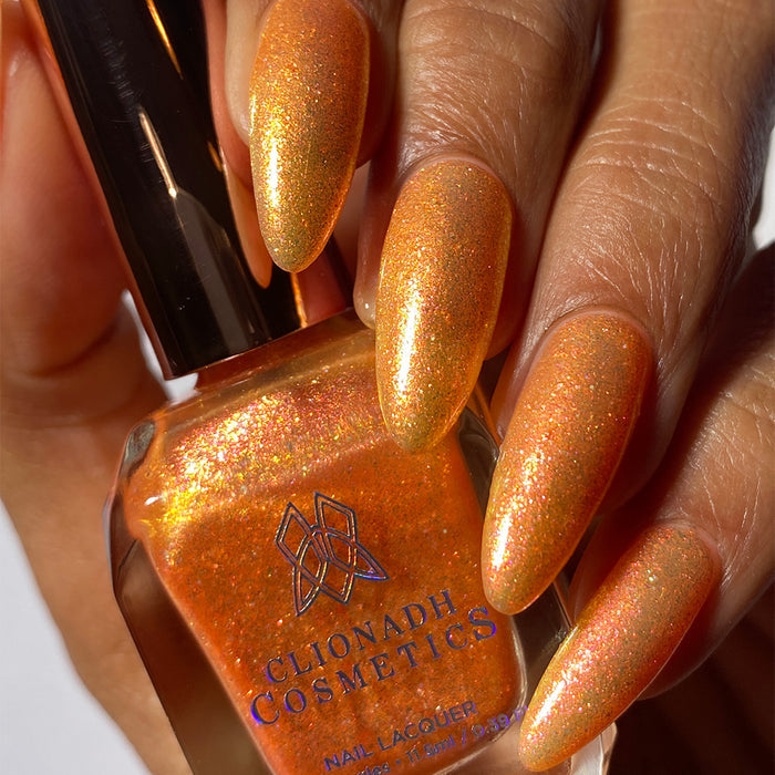 Close-up of nails painted with Yuzu Limonada Nail Lacquer on medium skin tone. Hand is holding polish bottle.
