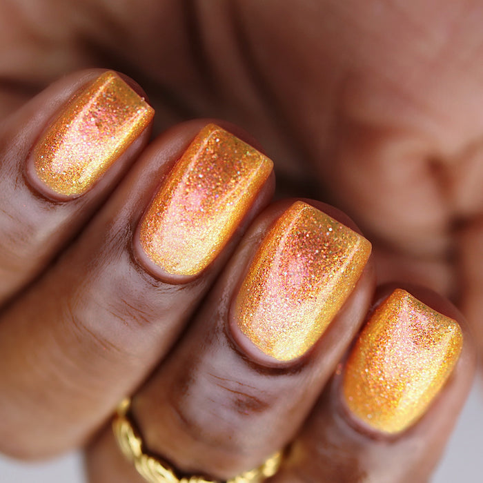 Upside-down close-up of nails painted with Yuzu Limonada Nail Lacquer on deep skin tone.