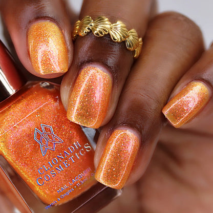 Close-up of nails painted with Yuzu Limonada Nail Lacquer on deep skin tone. Hand is holding polish bottle.